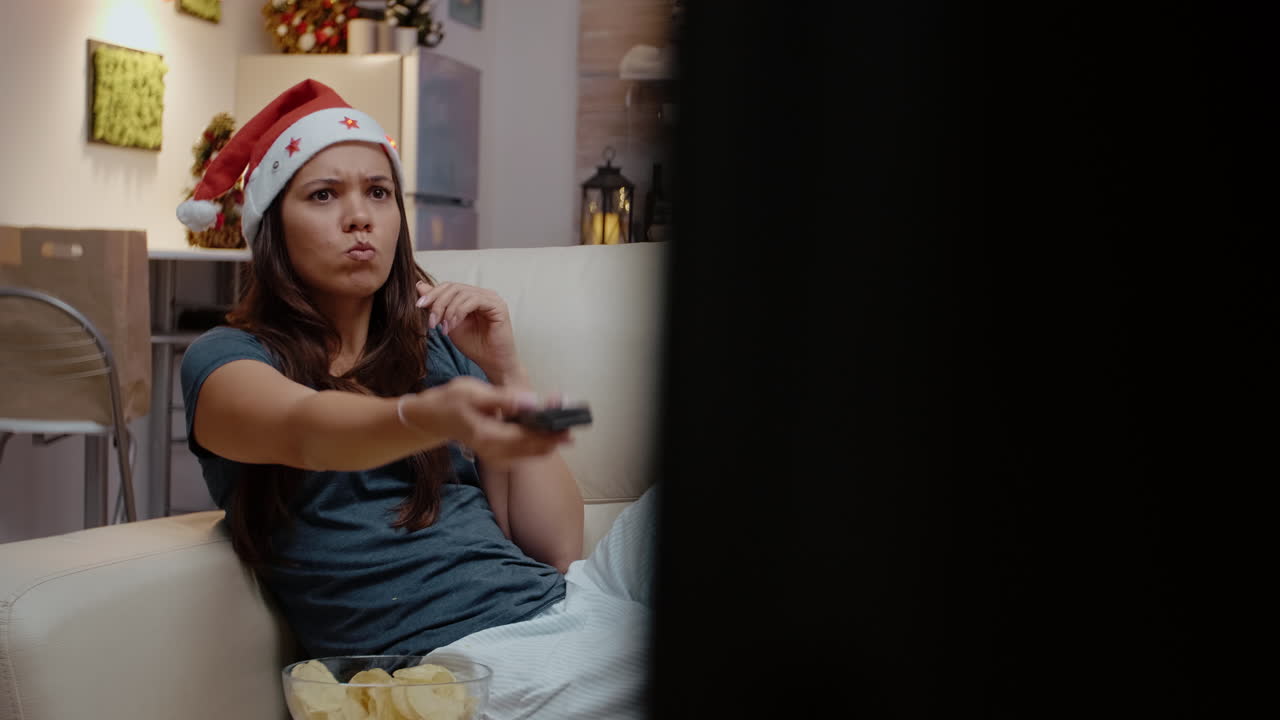 Persona frustrata che cambia canale in TV usando il telecomando