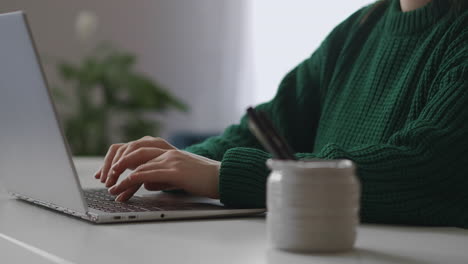 aprendizaje electrónico y educación a distancia primer plano de las manos de una estudiante en el teclado de una computadora portátil escribiendo y enviando mensajes detalle disparado en la mesa de trabajo