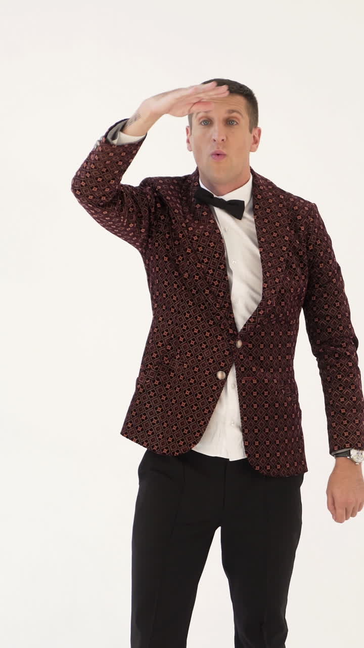 showman in a suit with a funny jacket is depicting a man who plays golf on a white background in the studio Vertical video