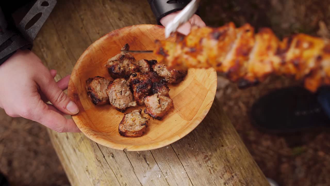Man removes shashlik from skewers. Grilled meat shish kebab .