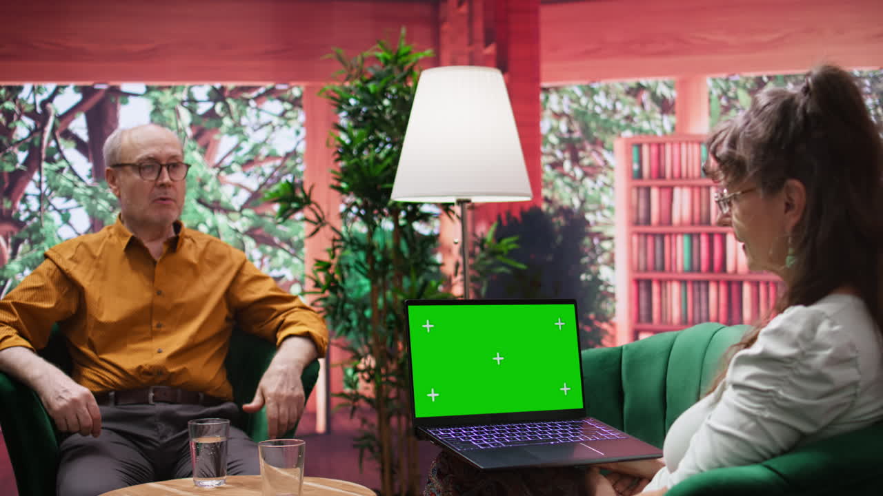 una pareja de ancianos en un hogar cómodo disfrutando de una conversación junto a una exhibición de maquetas