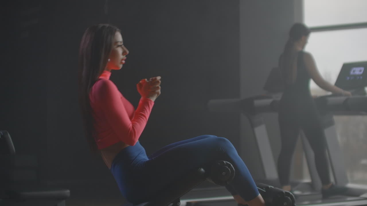 The girl pumps the muscles of the upper and lower abs. She bends and extends the body on a bench.