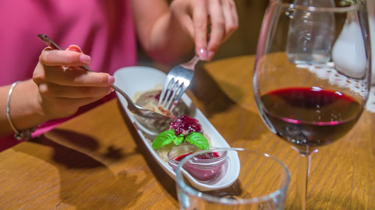 Mulher comendo deliciosa sobremesa de sorvete com taça de vinho tinto.