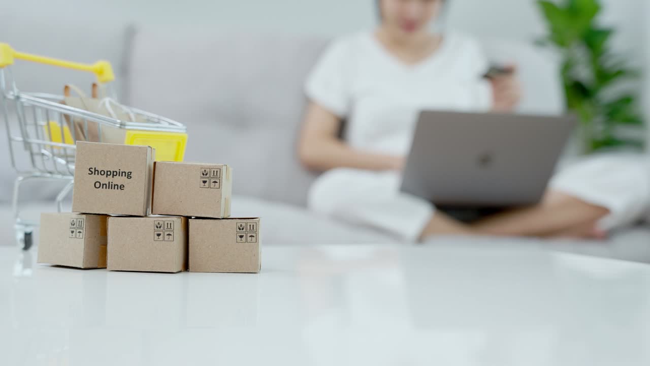 las mujeres asiáticas están pagando en línea con tarjeta de crédito en casa. las mujeres están comprando las cosas que les gustan en sus computadoras. el concepto de compras en línea las compras en línea son una forma de comercio electrónico.