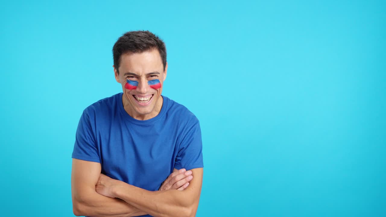 Man standing with haitian flag painted on face smiling