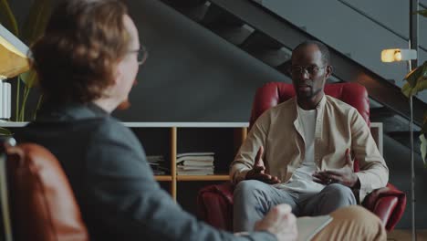 black man sharing problems with psychologist during therapy session