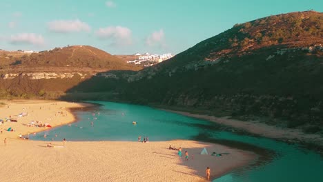 Flying Over Turquoise Waters And Sandy Beach Crowded With People Enjoying Summer Time, Portugal
