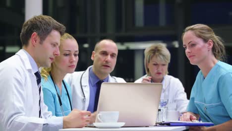 Equipo-De-Médicos-Discutiendo-Sobre-Una-Computadora-Portátil-En-La-Sala-De-Conferencias