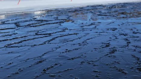 Ice is thin and melting on a lake during spring or late winter.