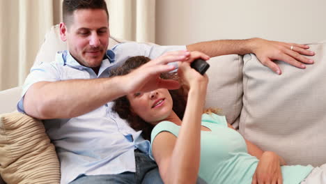 una pareja feliz relajándose en el sofá viendo la televisión.