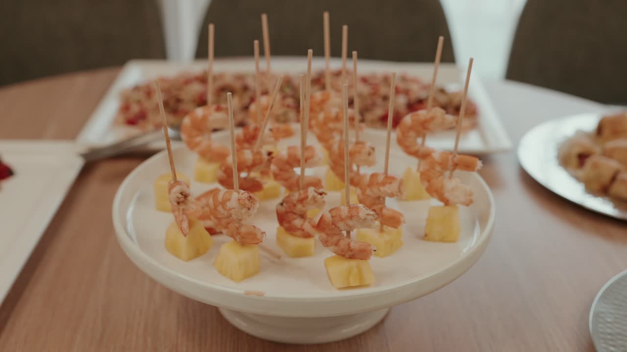 Close view of shrimp skewers with pineapple cubes served on buffet plate