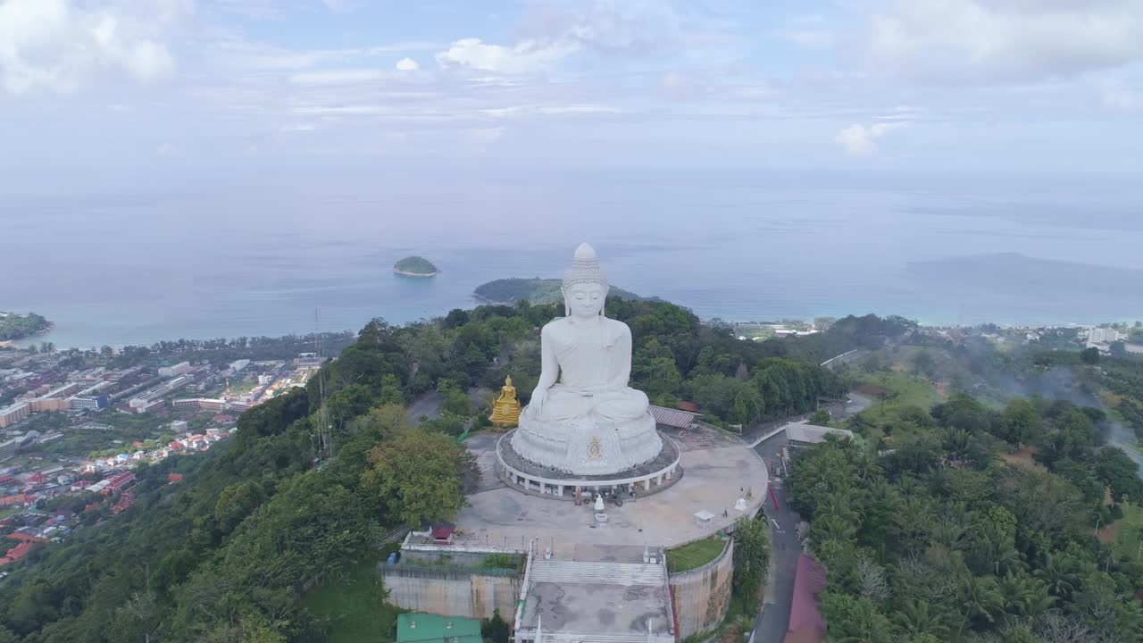 Aerial View drone shot of White Marble Big Buddha Statue on the high mountain peak at Phuket thailand,Beautiful landmark in Phuket island,Popular tourist to see landscape view around the phuket island