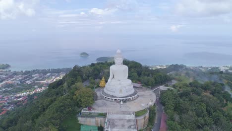 aerial view drone shot of white marble big buddha statue on the high mountain peak at phuket thailand,beautiful landmark in phuket island,popular tourist to see landscape view around the phuket island