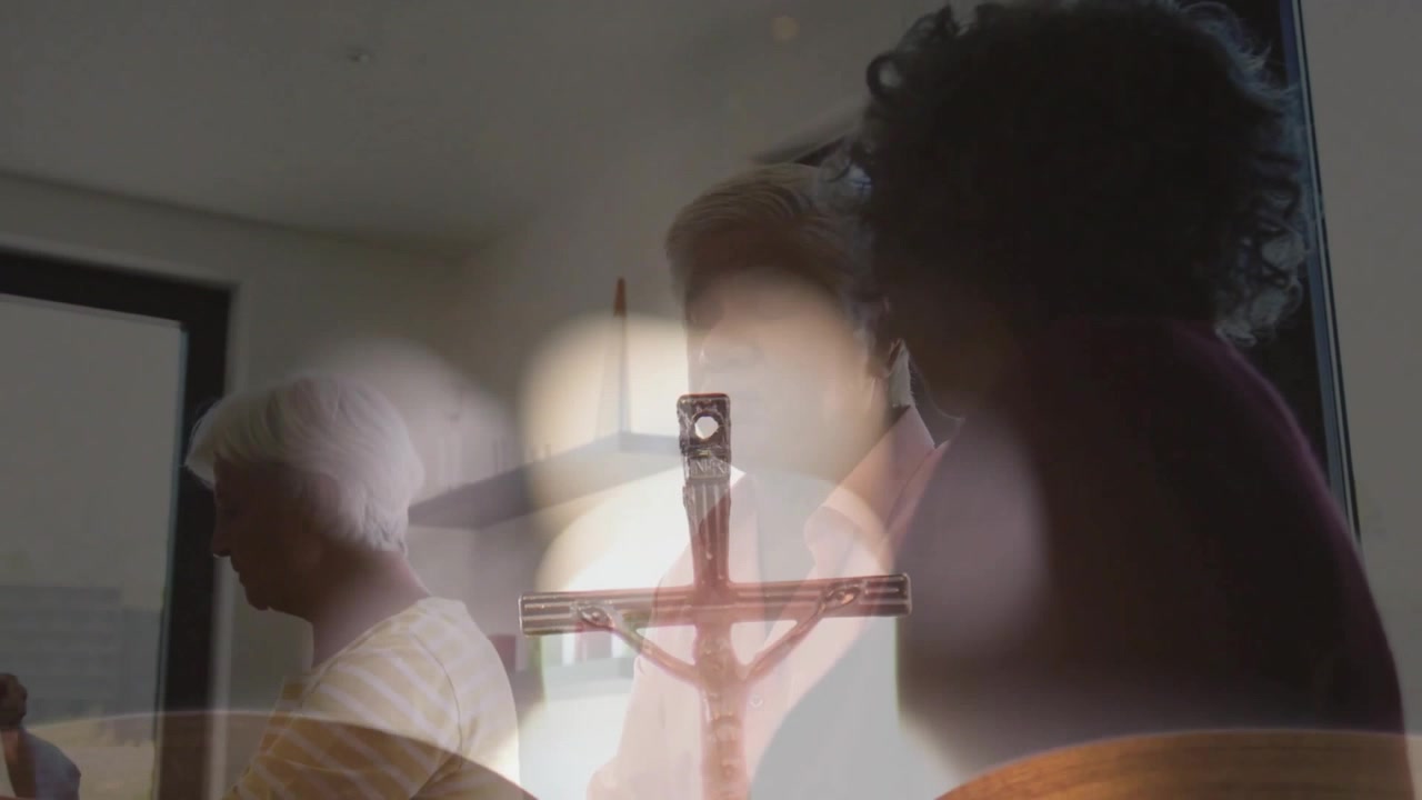Three seniors arranging items at table for health, candle flame appearing and crucifix fading in