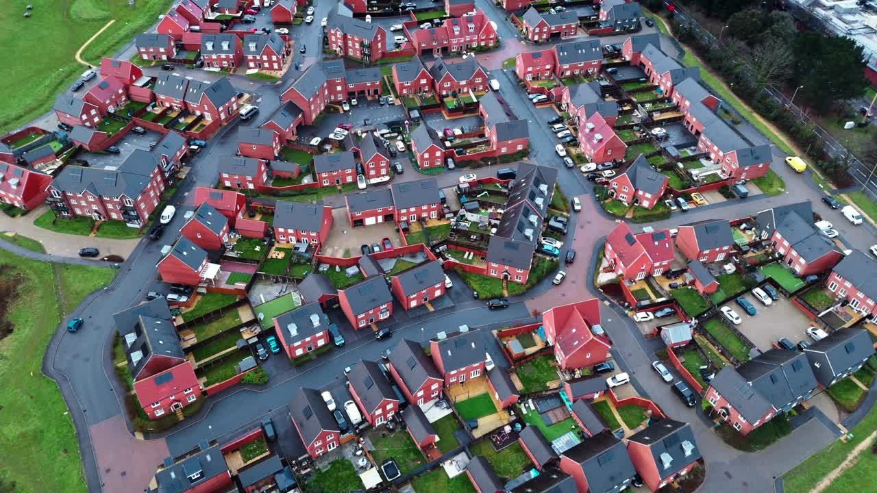 Luftoptagelser med drone over et lokalt engelsk forstadskvarter i det sydlige England ved tusmørke og solnedgang. Med befærdede veje og en rolig atmosfære med haver, træer og en dam