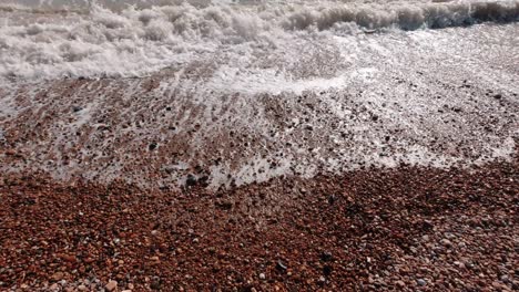 close up of smooth waves at pebble beach in pevensey in south england