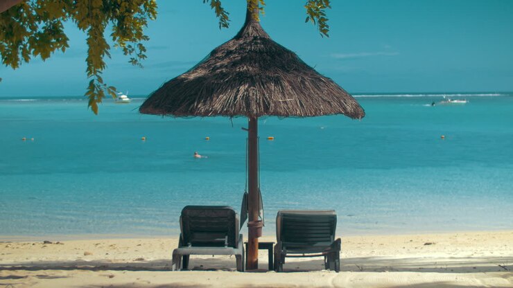 Costa dell'oceano con chaise longue e ombrellone