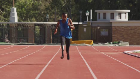 disabled mixed race man with prosthetic legs running on race track