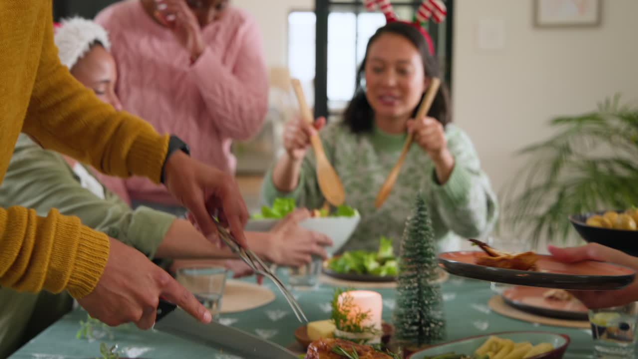 At christmas, diverse friends enjoying festive meal together, sharing salad and holiday at home