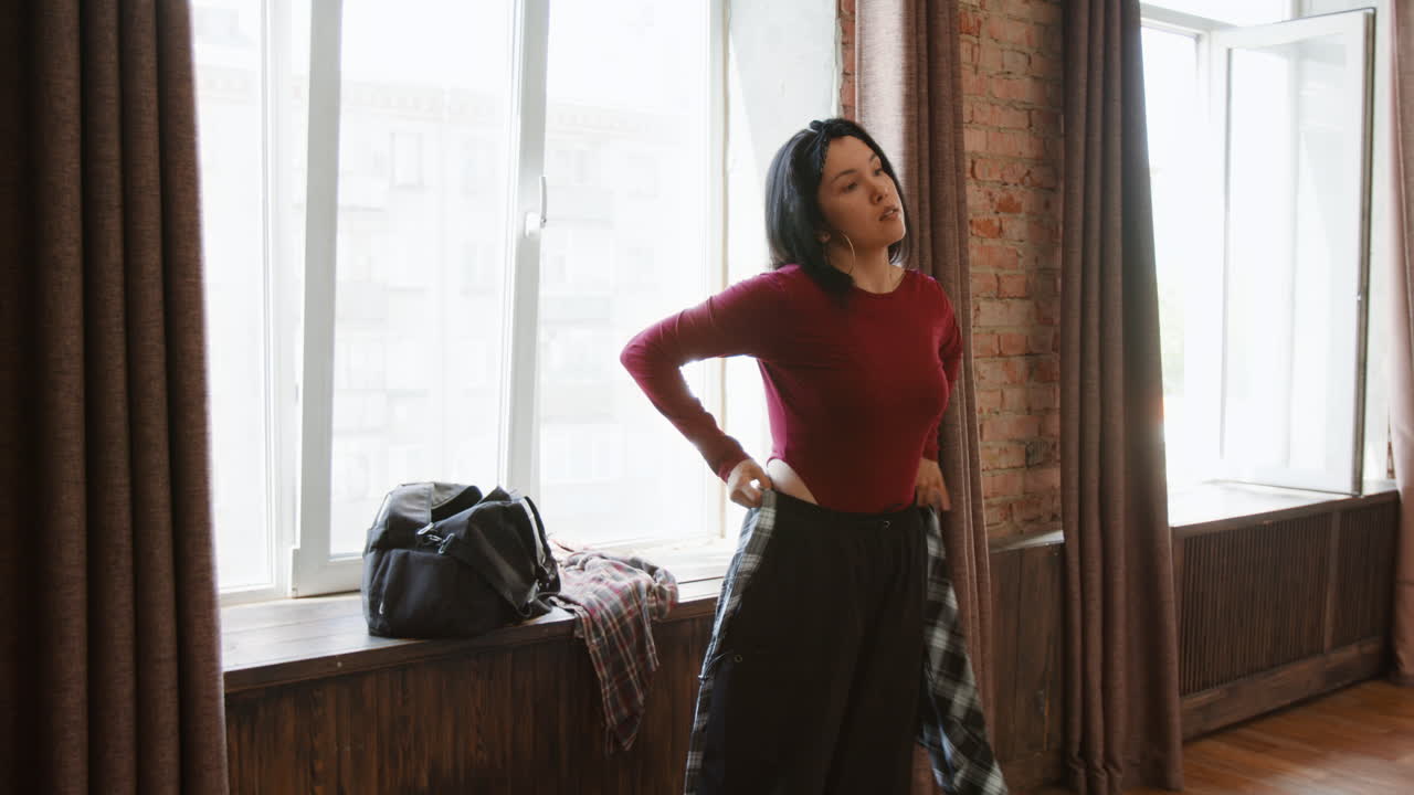 Young Woman Dressing in a Spacious Studio