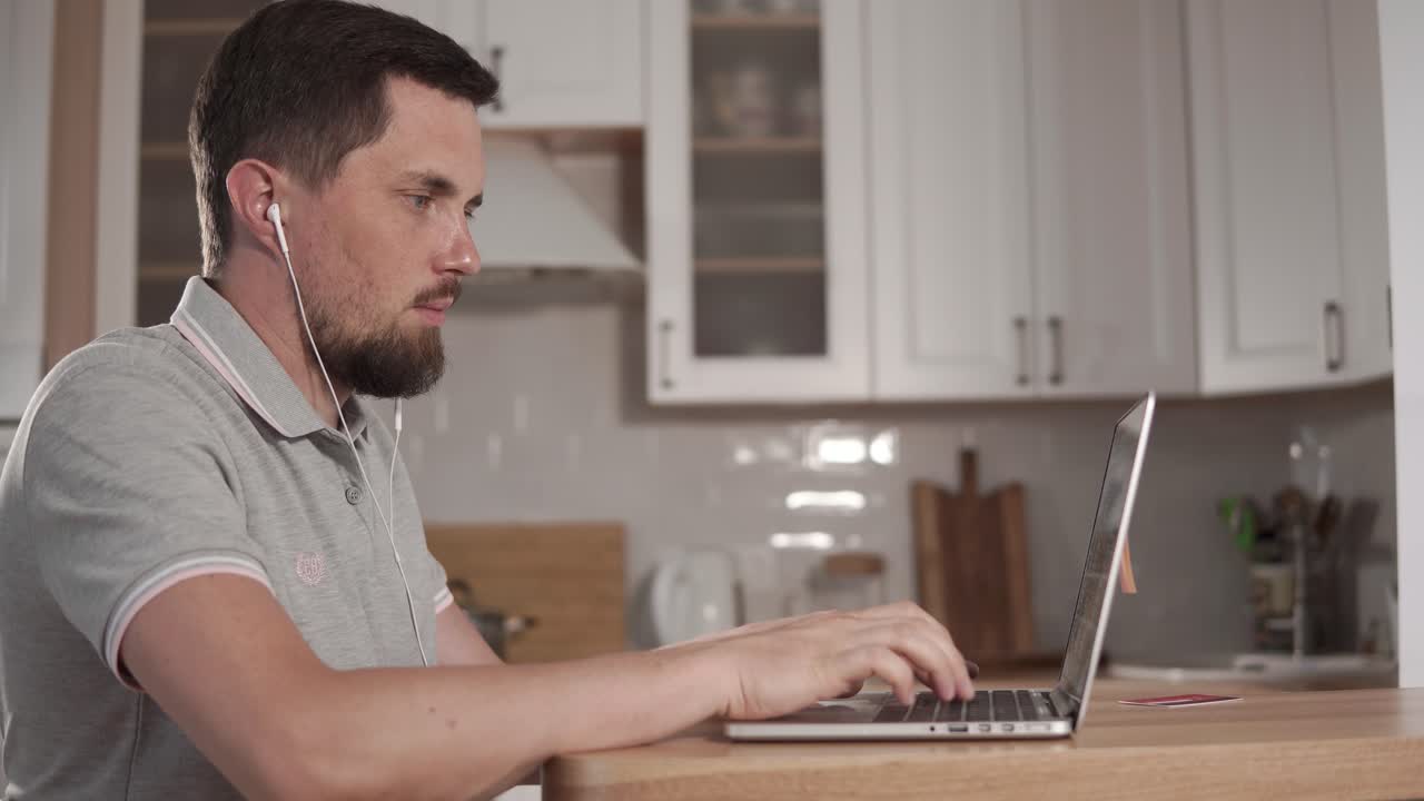 Man working on a laptop in a kitchen