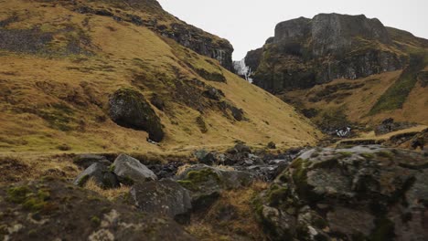 caminar cerca del lecho rocoso del río con el arroyo de agua del glaciar a través del valle de la montaña