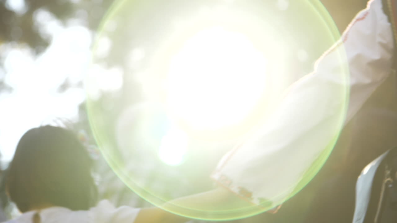 노인과 젊은이들은 아름다운 황금빛 백라이트 태양과 함께 손을 잡고 느린 동작으로 춤을 춥니다.