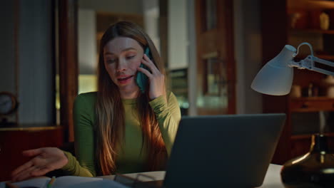 smiling freelancer calling night home close up. woman talking looking laptop