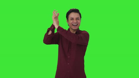 un maestro indio feliz aplaudiendo y apreciando la pantalla verde