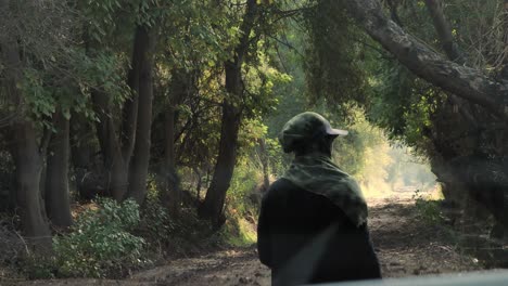 a wild life photographer walks towards a forest road in pakistan