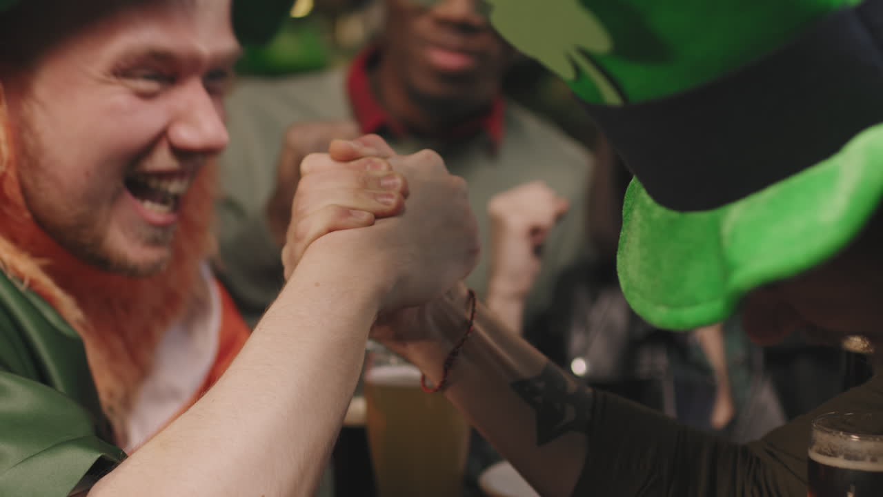 Male Friends Arm Wrestling In Pub