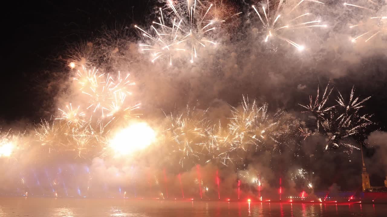fuegos artificiales coloridos festivos e iluminación en el cielo oscuro con un hermoso reflejo en el agua. velas escarlata de vacaciones