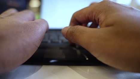 hands typingon a laptop, blurred background, close-up, indoor setting