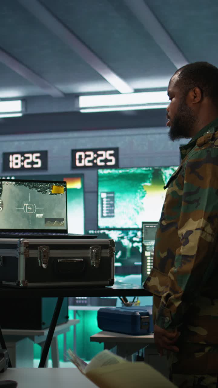 Vertical video Army expert examining data in monitoring room with laptop