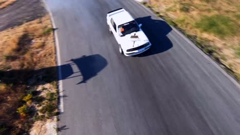 aerial action shot of race cars drifting on track with tire smoke