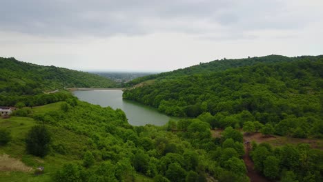 Un-Hermoso-Lago-De-Presa-En-Medio-De-Un-Bosque-Verde-En-La-Selva-Caspia-De-Hyrcanian-En-Azerbaiyán-Baku-Y-Paisaje-Urbano-En-El-Paisaje-De-Fondo-En-Un-Cielo-Nublado-Día-Semi-Soleado