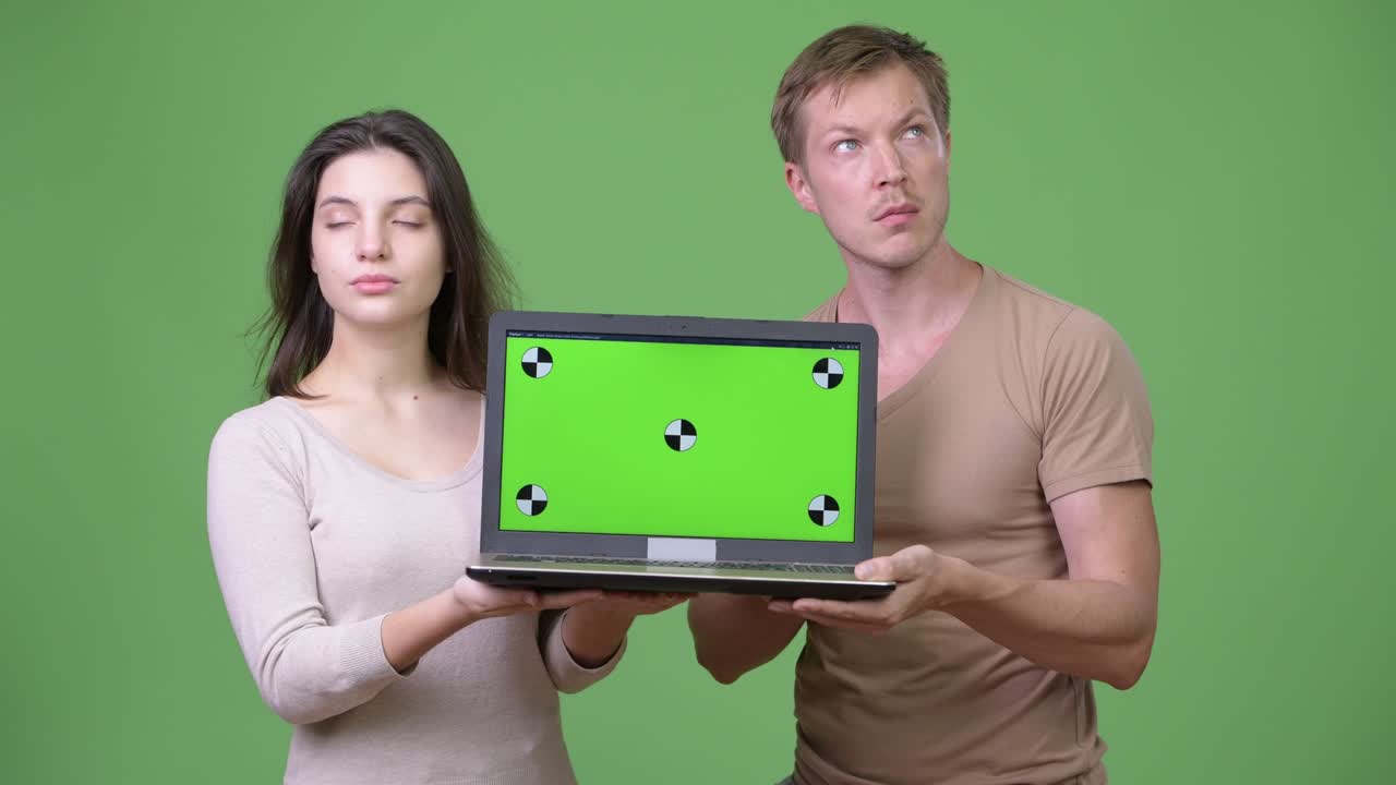 Young couple showing laptop and thinking together