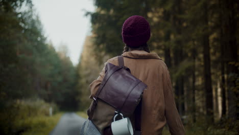 joven explorador con mochila mirando alrededor en el bosque