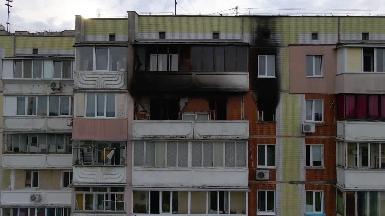 vista aérea frente a un viejo edificio exterior, con apartamentos quemados y llenos de hollín, en un triste barrio pobre de kiev, día nublado, en kiev, ucrania - levantamiento, disparo de avión no tripulado