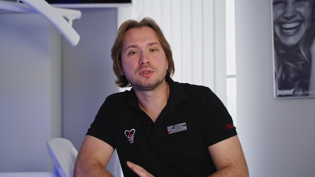 Dentist looking at camera. Male dentist against medical office background