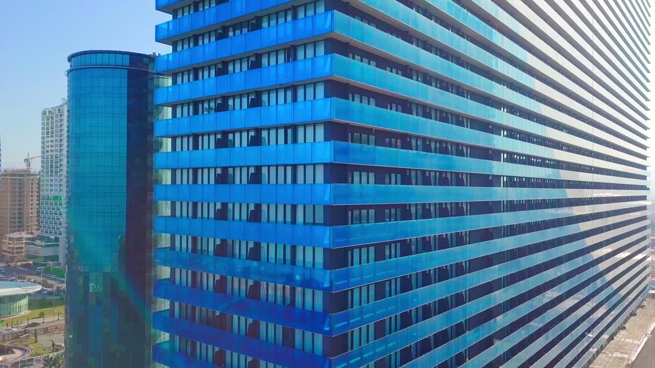 fotografía de los reflejos del sol, las nubes y el cielo en las ventanas de vidrio de los rascacielos de la ciudad.