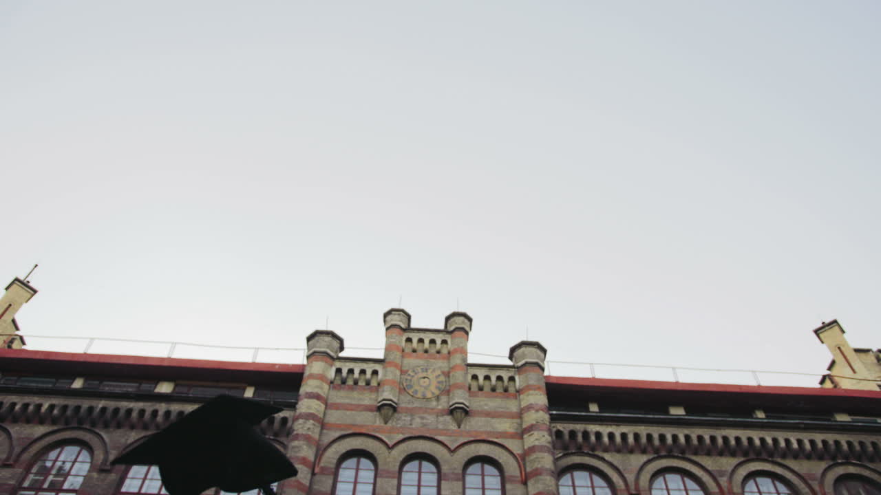 통로를 통해 졸업생을 걷고 검은 모자를 던지는 뒷모습