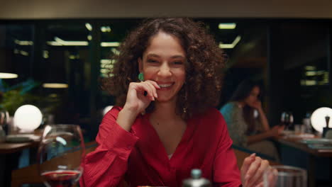 una mujer riendo mirando a la cámara en una cena romántica en un restaurante de lujo.