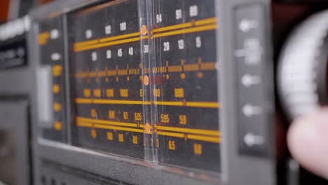 female fingers adjusting the frequency on an old vintage analog receiver