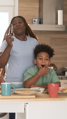 mother and son having breakfast in the kitchen