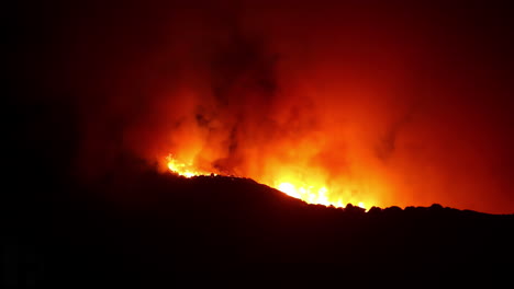 Infierno-De-Fuego-Salvaje-En-Llamas,-Rodando-Sobre-Montañas,-Durante-La-Noche---Lapso-De-Tiempo