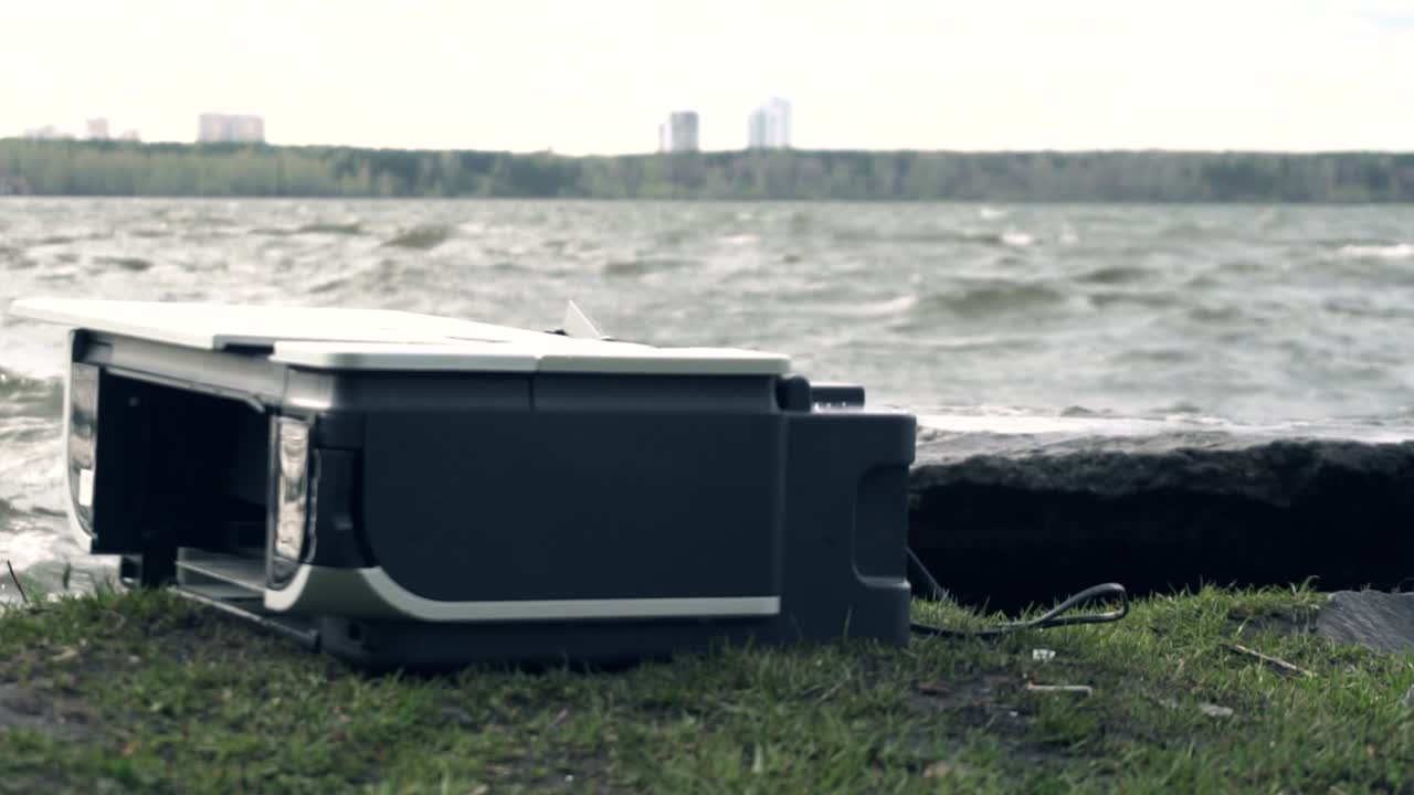 프린터 가 강변 근처 에서 망치 로 파괴 되고 있다