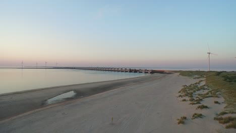 항공: 여름 일몰 동안 oosterschelde 폭풍 해일 장벽 주변의 해변