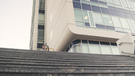 food delivery man down the stairs carrying his bike