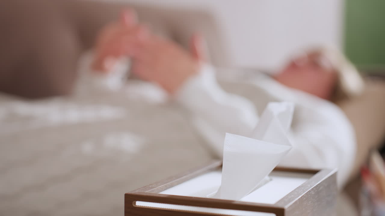 Wipes pack on table in restorative space with blurred young woman lying in recliner moving hands gently conveying comfort and self care mood under soft warm lighting for therapeutic ambiance